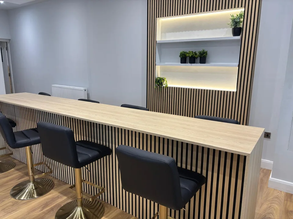 Nail desk with black chairs and illuminated mirror in Thorne