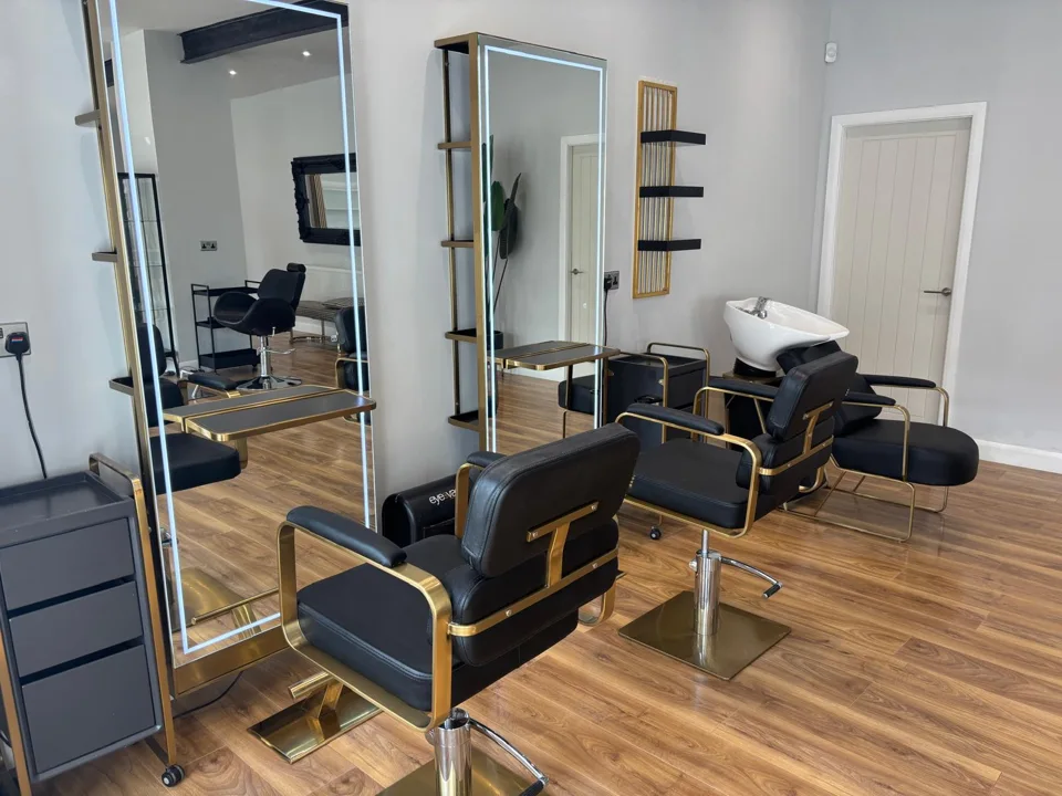 Black styling chairs and tall mirrors inside the Thorne salon